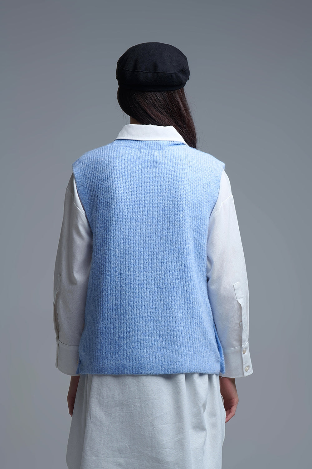 Blue sleeveless sweater with gold buttons on side
