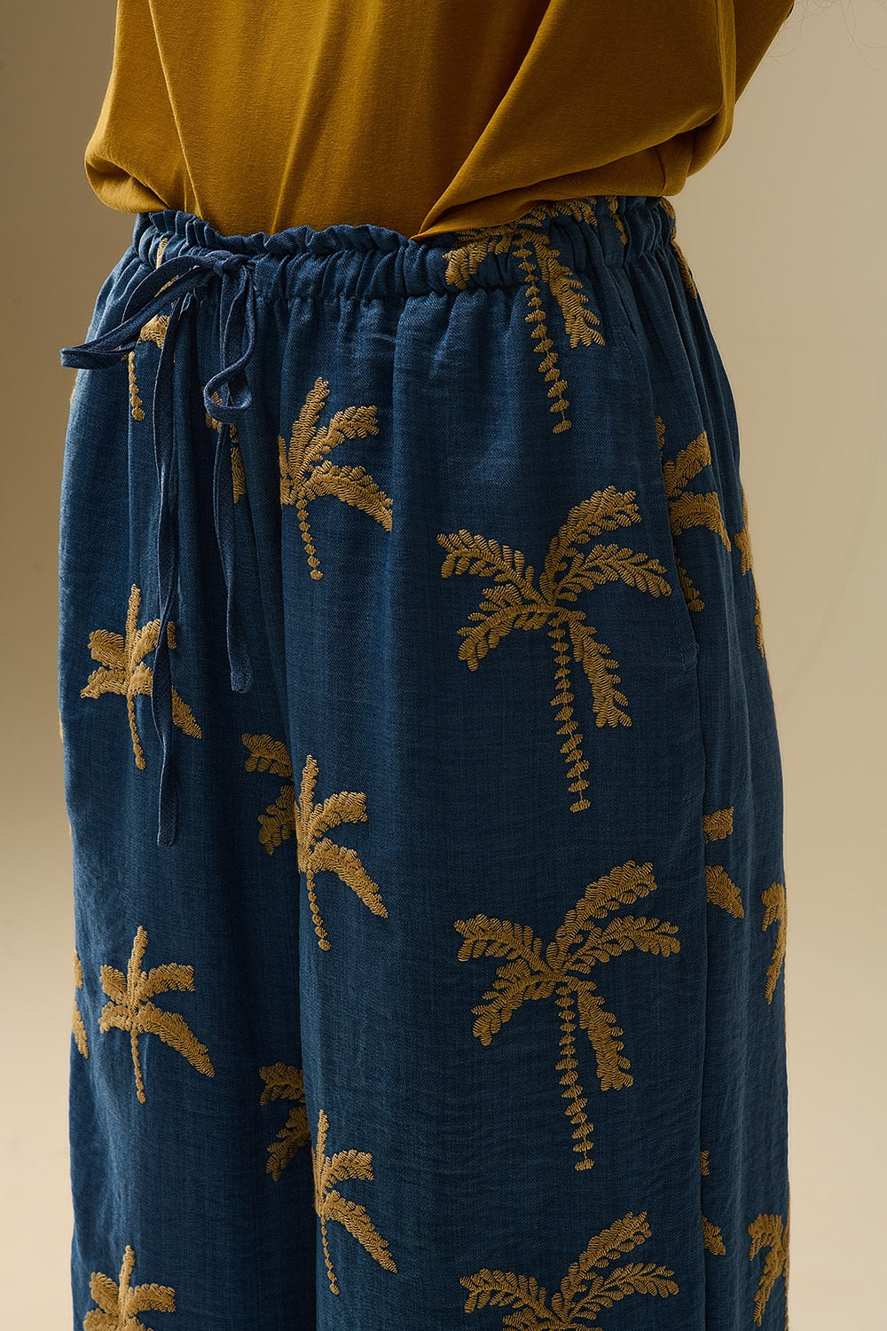 Blauwe wijde broek met beige palmboomborduursel