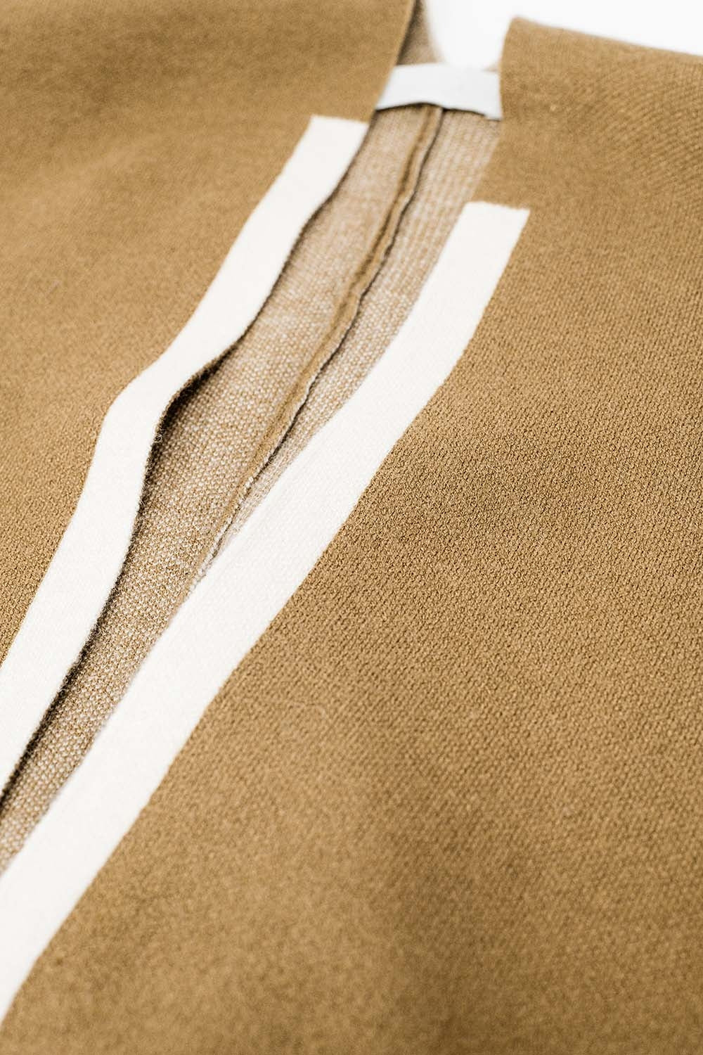 Gebreide poncho in camel met ecru rand