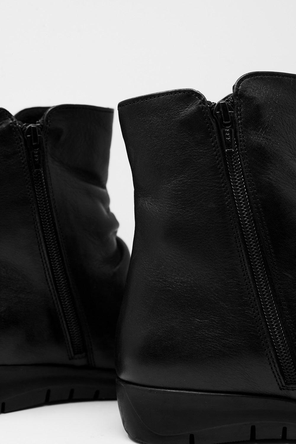 Lage zwarte laarzen met rits en ronde neus
