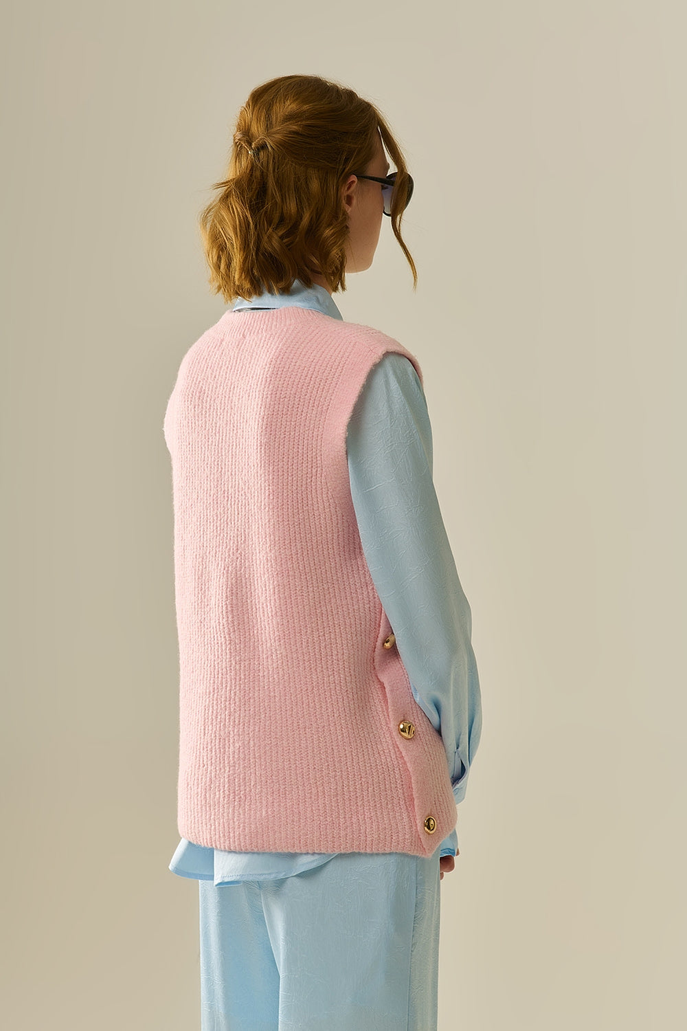 Pink sleeveless sweater with gold buttons