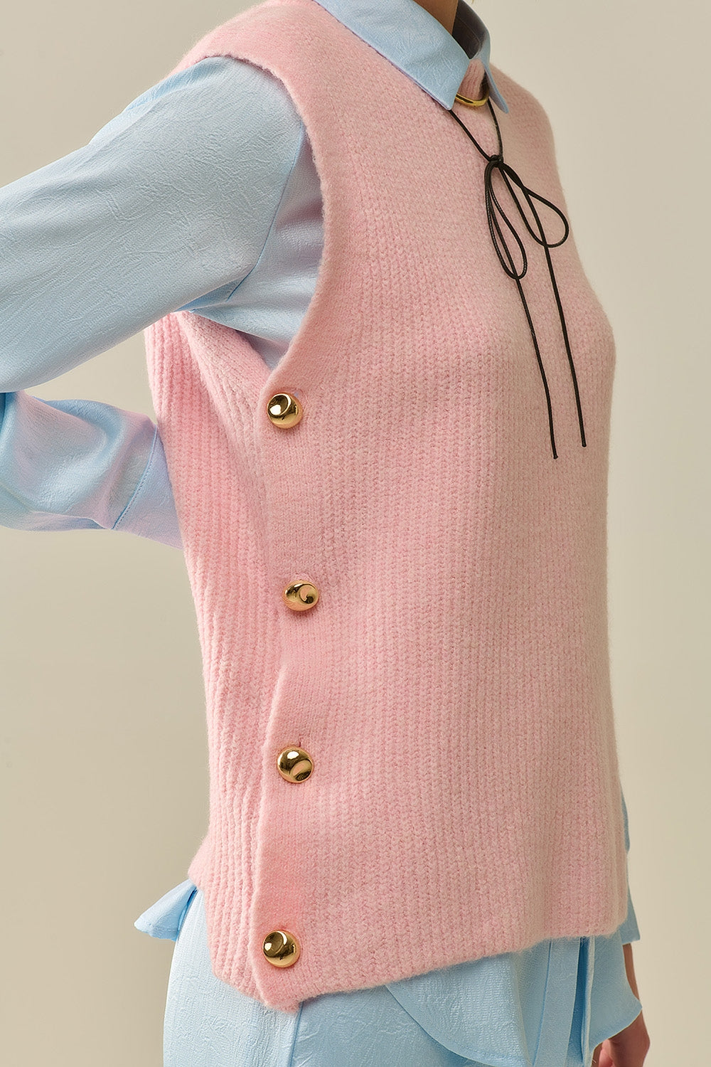 Pink sleeveless sweater with gold buttons