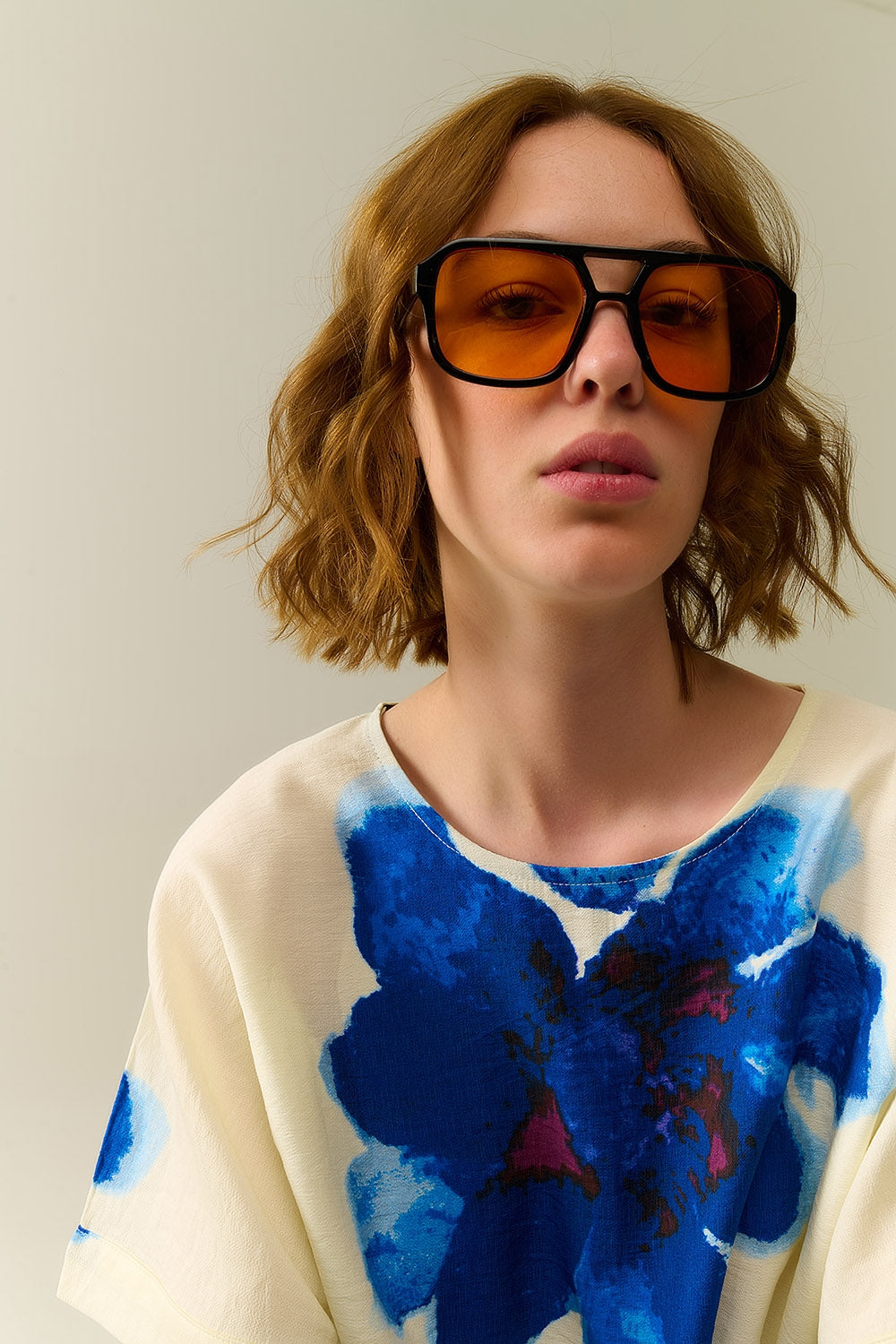 Óculos de sol com armação preta e lentes laranja