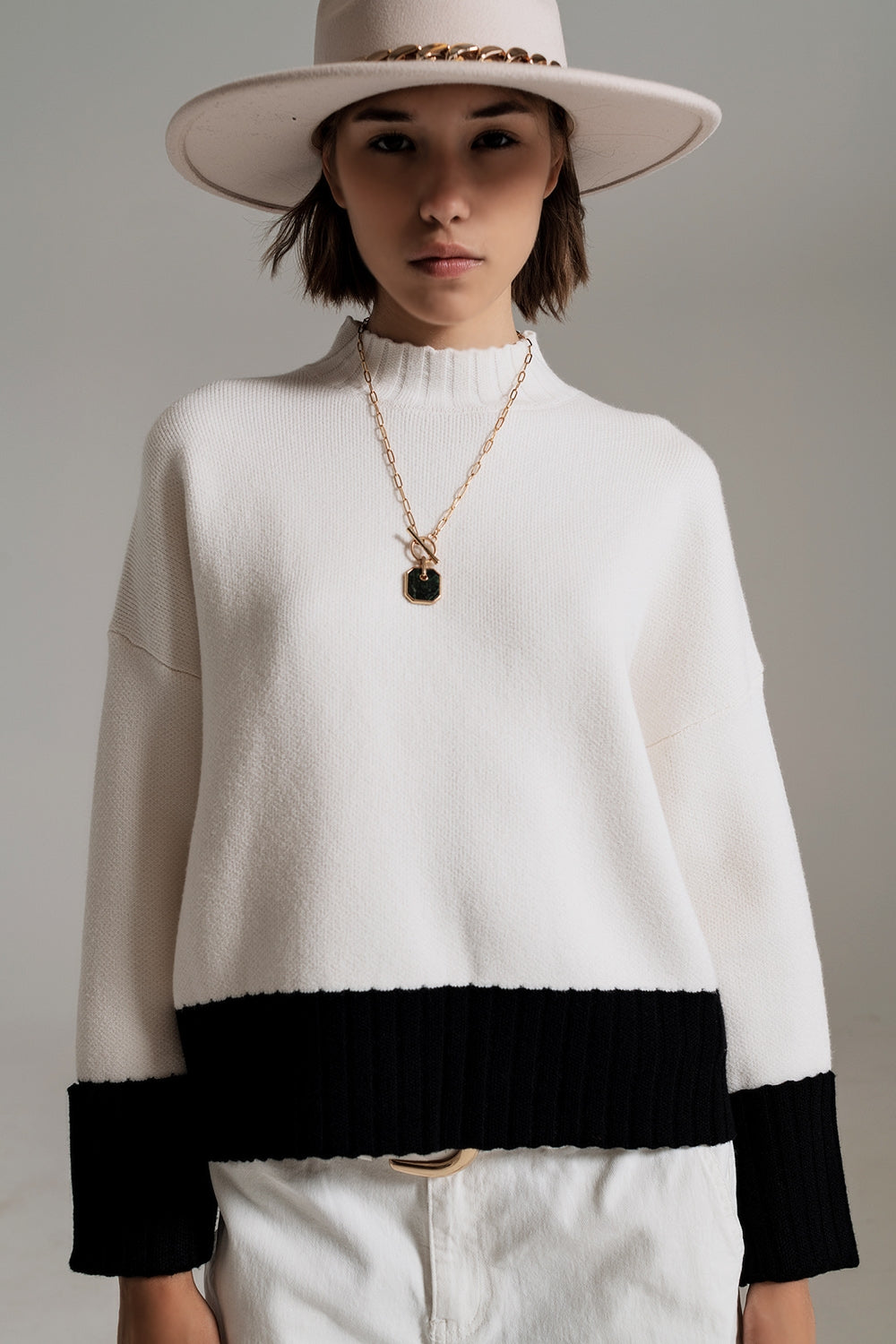 white jumper with black ribbed cuffs and hem