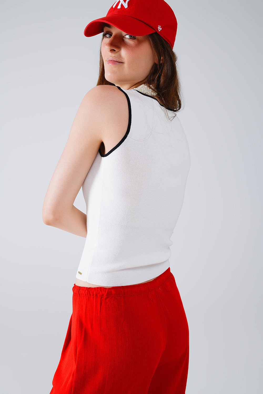 White sleeveless top with crew neckline neckline and black trim