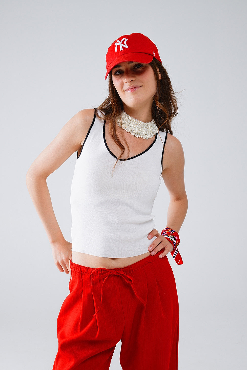 Q2 White sleeveless top with crew neckline neckline and black trim