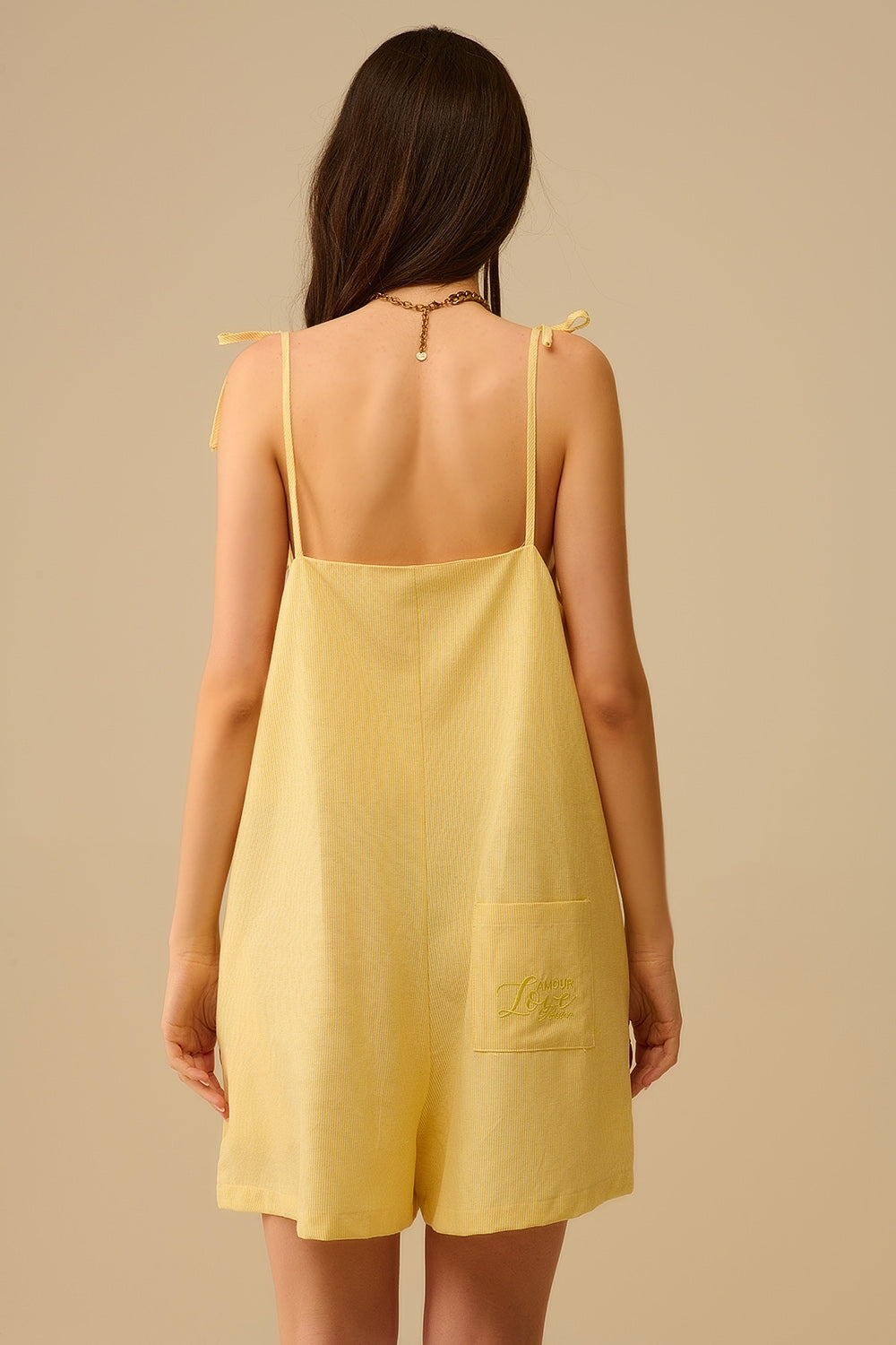 Yellow striped playsuit with shoulder ties and back pocket detail